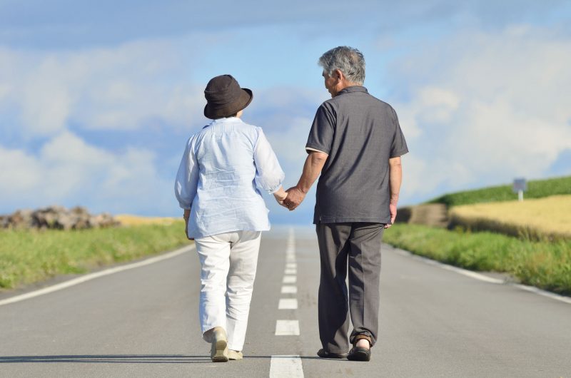 paylessimages150116672.jpg - senior couple walking a single road holding hands