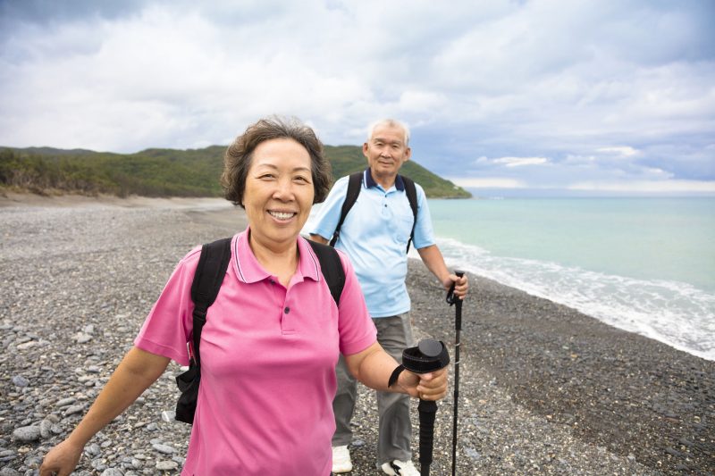 tomwang150800164.jpg - happy senior couple hiking on the coast beach