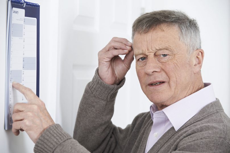 highwaystarz160300041.jpg - confused senior man with dementia looking at wall calendar