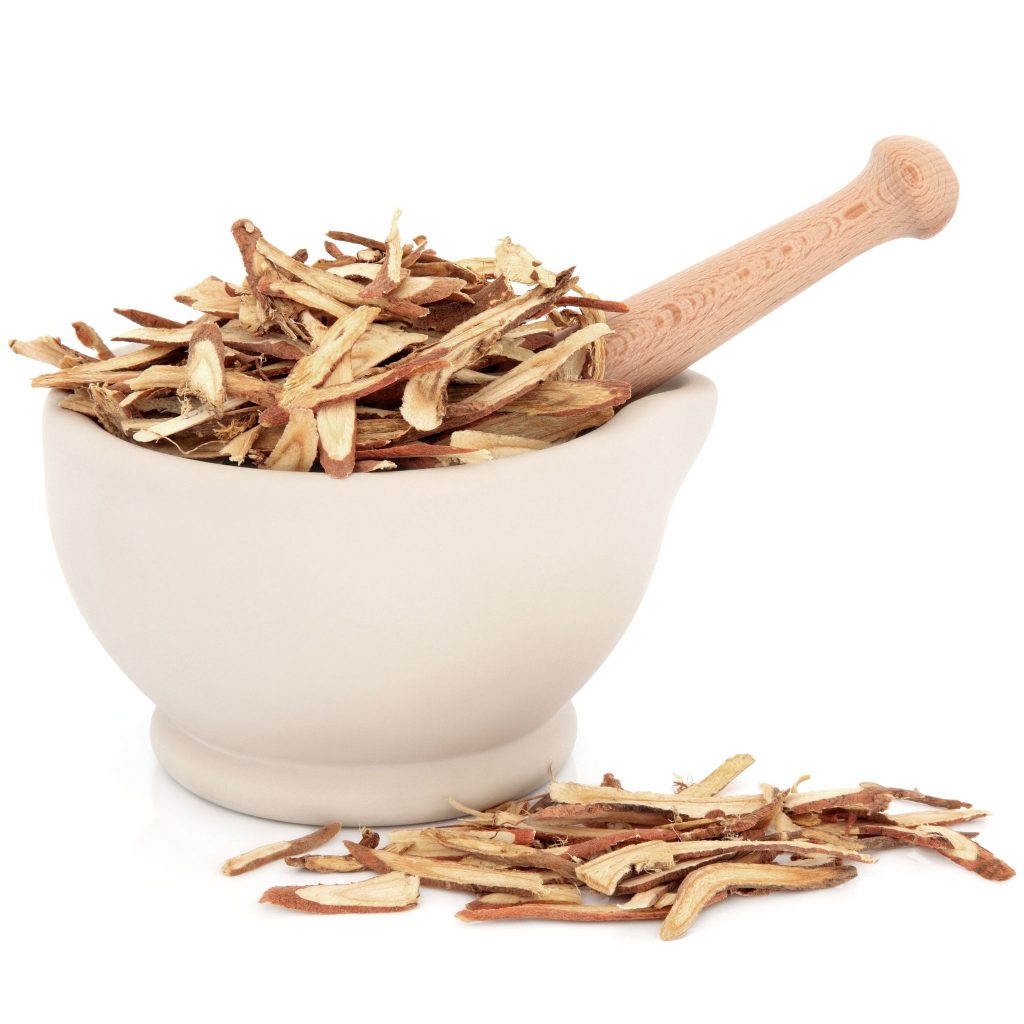 marilyna130600065.jpg - chinese herbal medicine of licorice root in a stone mortar with pestle over white background