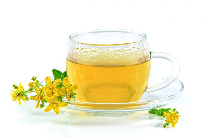 wdnet160700009.jpg - tea with st. john's wort in a glass cup isolated on a white background and the flowering herb hypericum