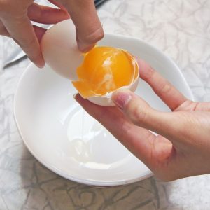 ratru111100150.jpg - the girl breaks egg in a cup