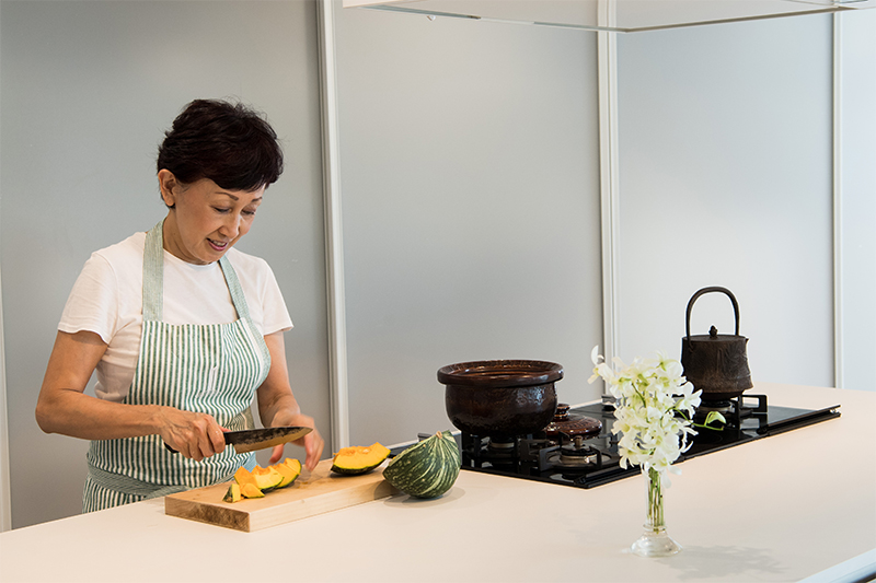 カボチャを切る料理研究家の松田美智子さん。広々とした石加工の調理台は、イタリアから取り寄せた特注。