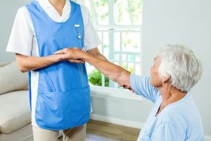Midsection of nurse assisting senior woman at health club
