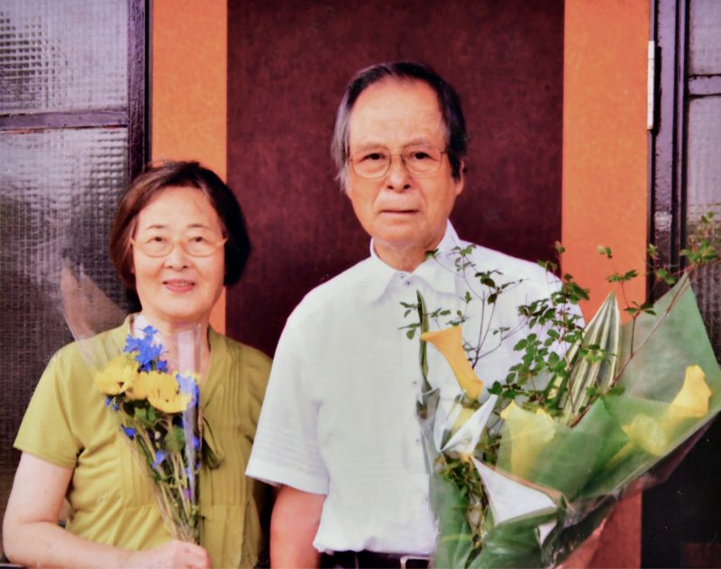 花束を手に持ち並ぶ両親