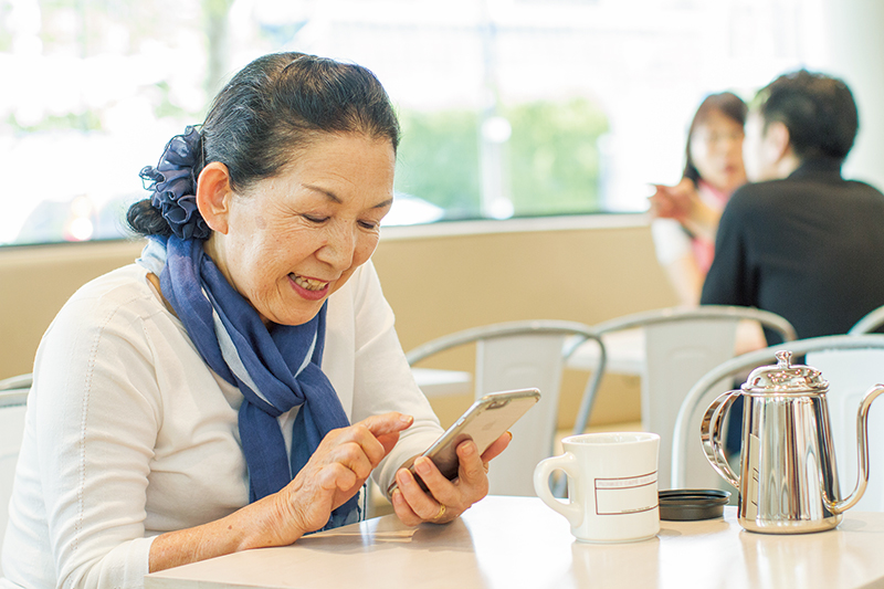 スマートフォンを操作する高齢女性