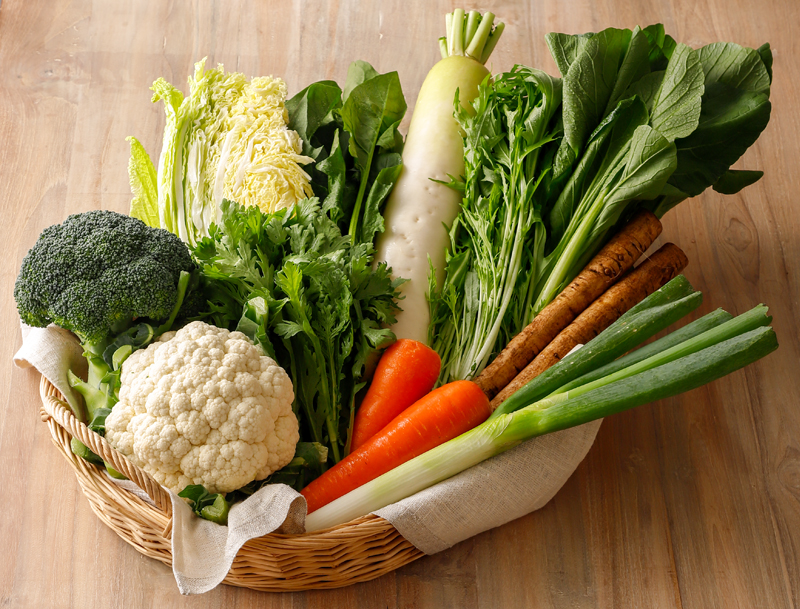 小松菜、大根、人参、白菜などたくさんの冬野菜がバスケットのなかに入っている