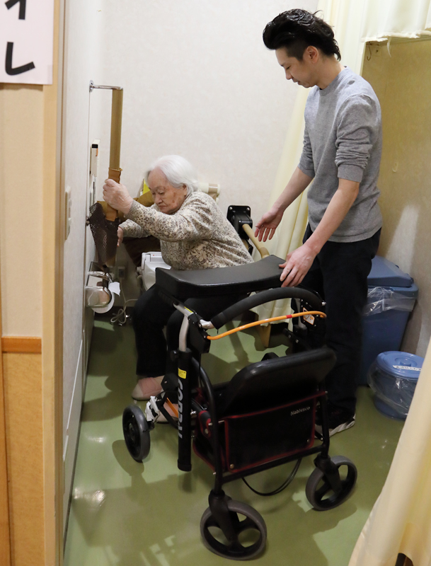 高齢者のトイレをアテンドする介護職員