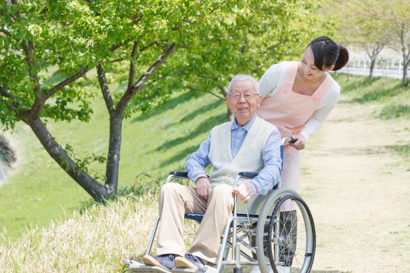 車椅子の高齢者とエプロンをした女性