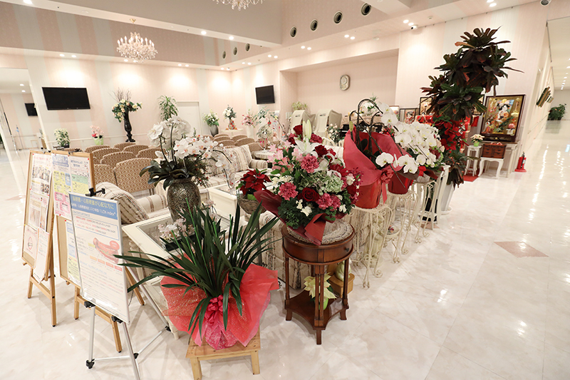 花がいくつも飾られ、たくさんの椅子が並んだ華やかなエントランス