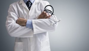 Doctor holding a stethoscope with arms crossed and copy space