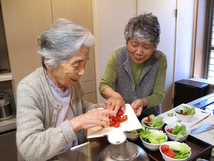 サラダの盛り付けをするグループホームの入居者