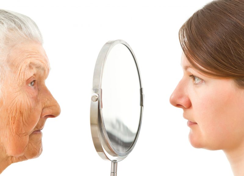 鏡を見る高齢の女性と若い女性