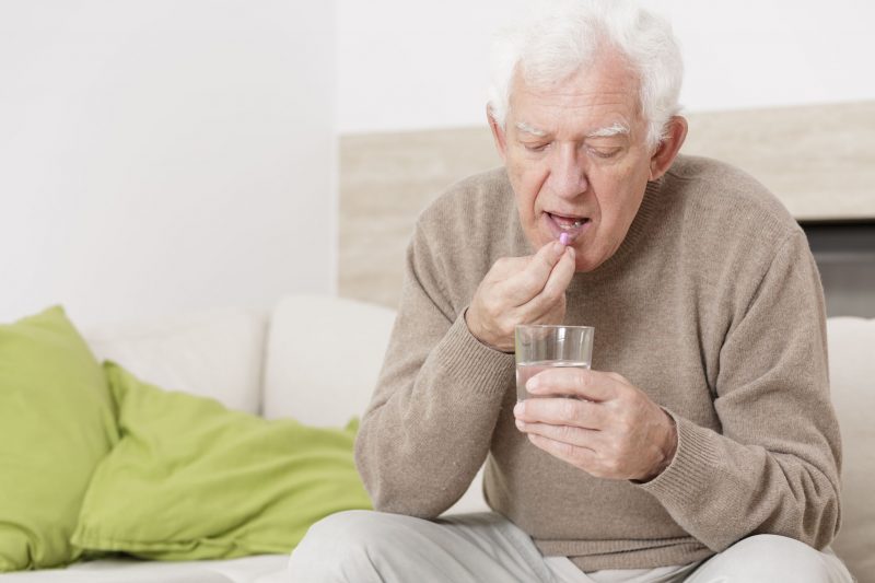 薬を飲む高齢の男性