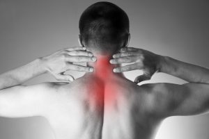 Pain in the neck. Man with backache. Pain in the man's body. Black and white photo with red dot