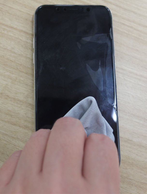 柔らかい布でスマートフォンの表面を拭く画像