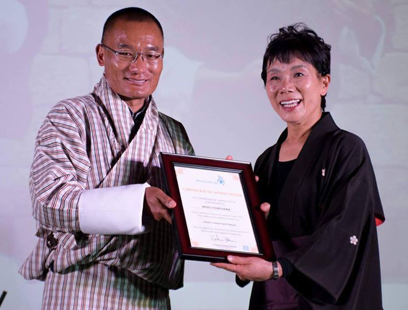 2017年、ブータンで首相主催のコンサートに出演し感謝状を受け取る鶴澤さん