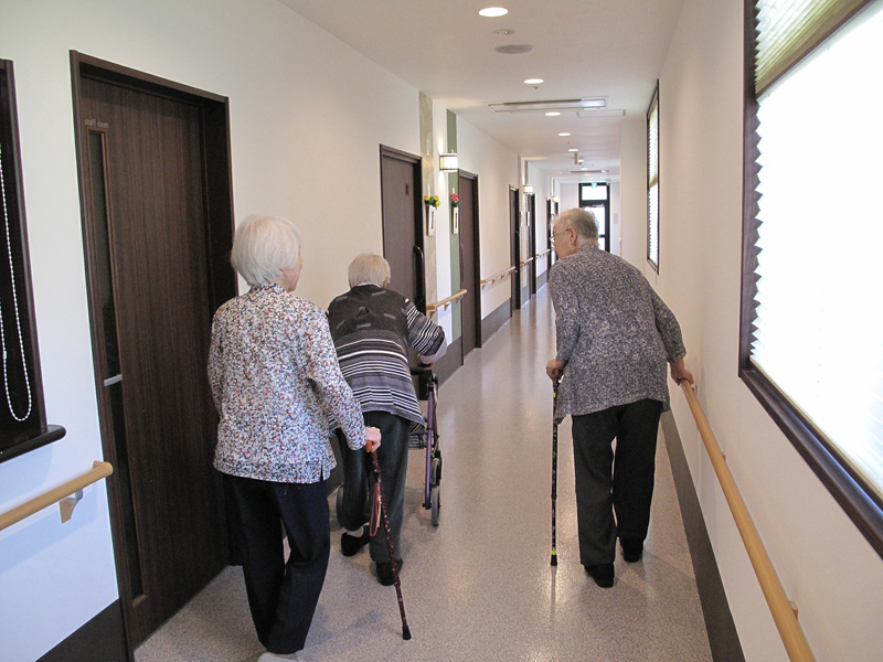 老人ホーム内を歩く高齢者たち