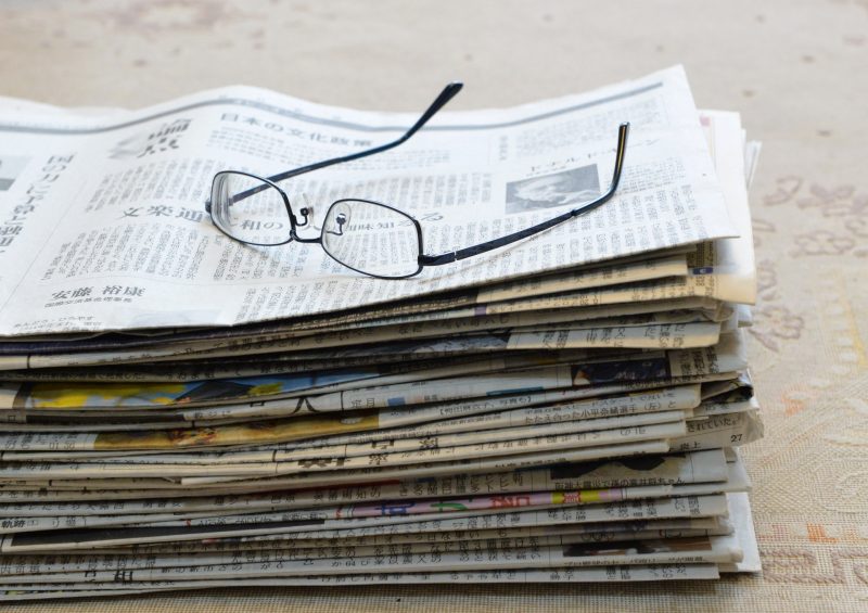 新聞紙の山と眼鏡
