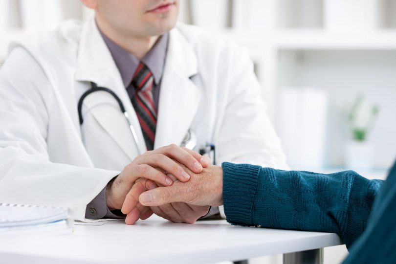 患者の手を触る男性医師