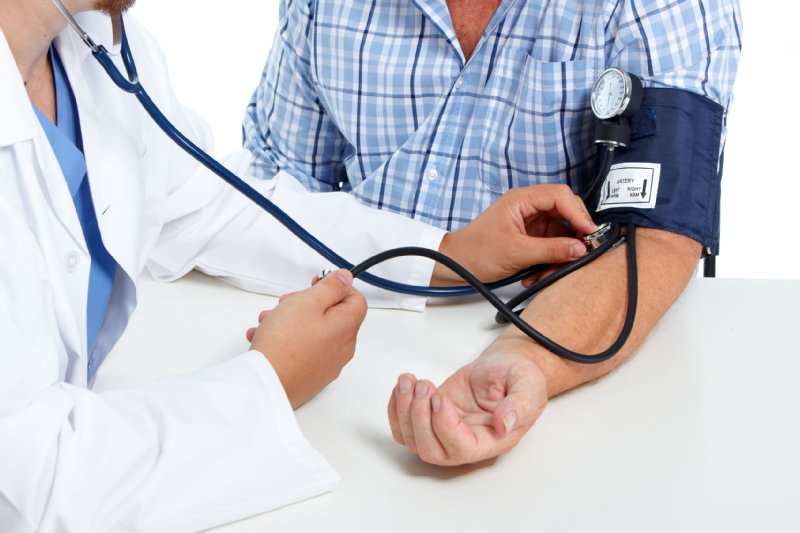 血圧を測る男性と医師の写真