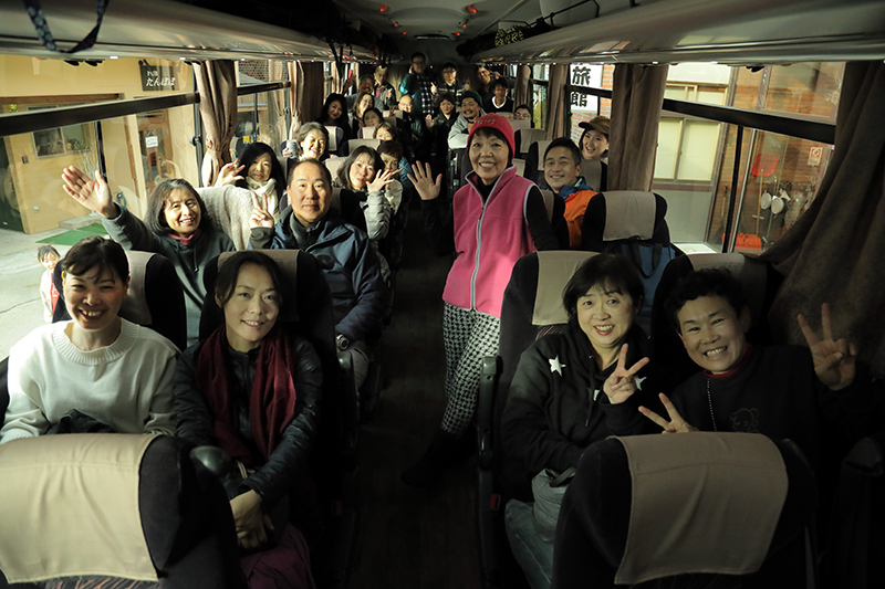 バスに乗ったツアー客たち。みんなそれぞれ笑顔を見せ写真に写る