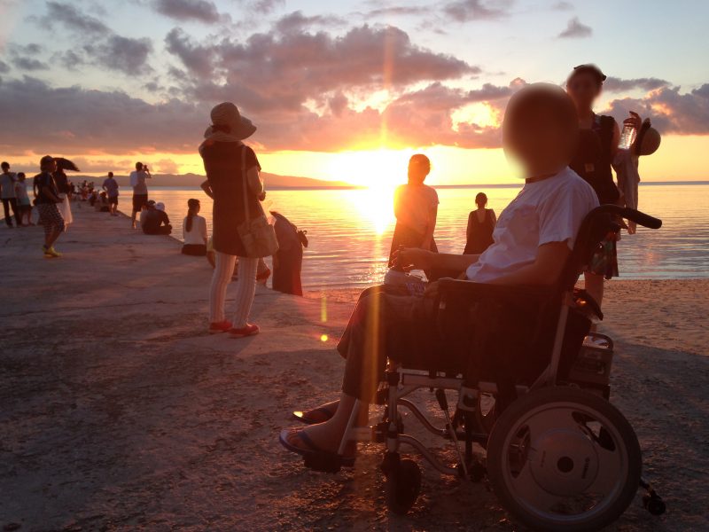 石垣島の海沿いで車椅子に乗っている女性