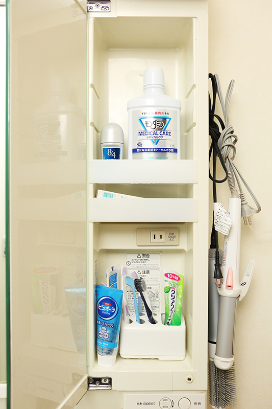 歯ブラシや歯磨き粉、ヘアアイロンなどを収納した洗面台上扉内の画像