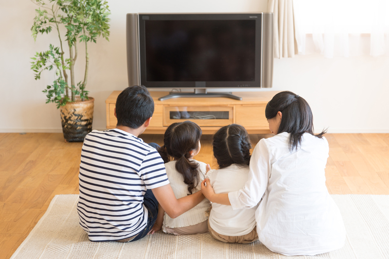 家族でずっとテレビを見ている写真