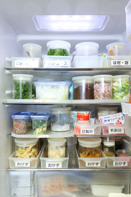 ラベルを貼ったトレーで食品が整理された冷蔵庫の中画像