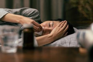 風邪で寝ている女性のイメージ写真