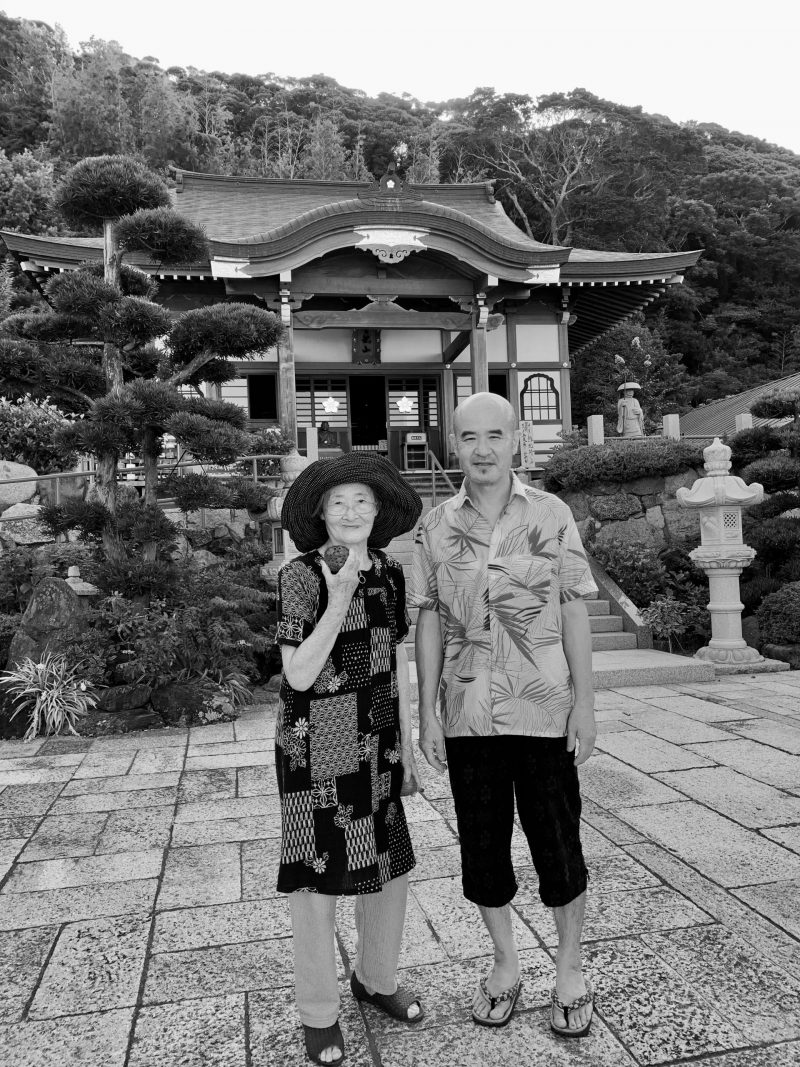 お寺の前で並ぶ飯田裕子さんの母と弟
