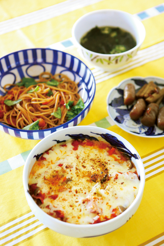 テーブルに、わかめの中華風スープ、ごぼうとこんにゃくのきんぴら、いろいろ野菜のイタリアン蒸し＆チーズ焼き、トマトの全粒粉パスタが並んでいる