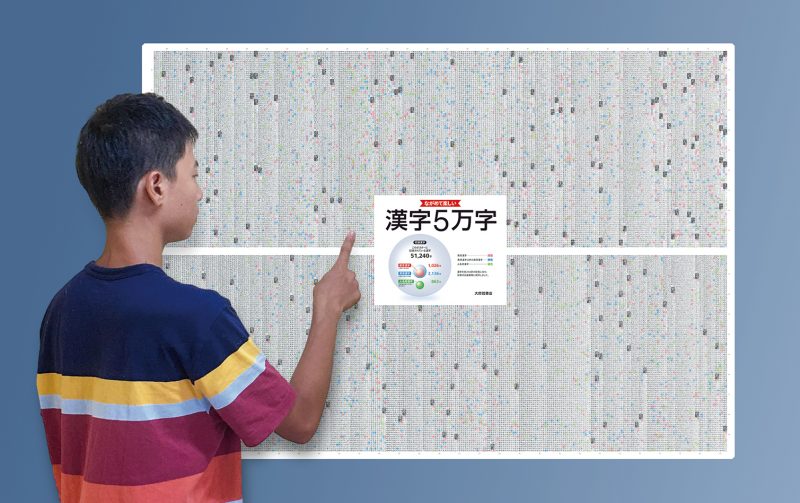 難読漢字のポスターを眺めている男の子の写真