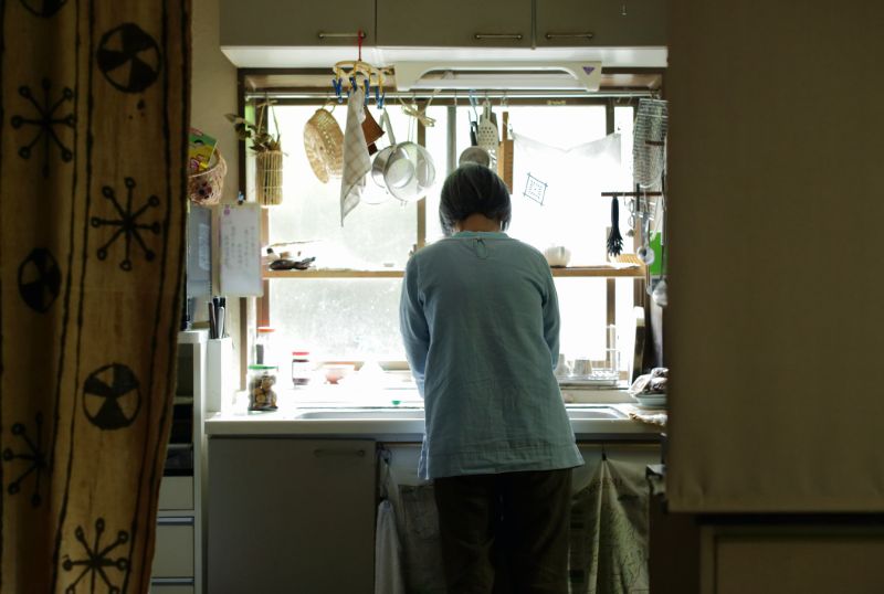 台所で洗い物をする中年女性