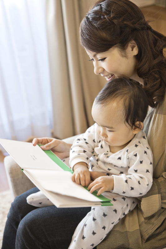 子供に読み聞かせしているお母さんの写真