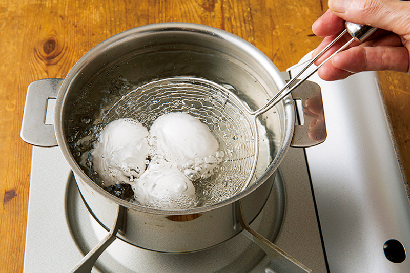 鍋に沸騰した湯に卵を入れている