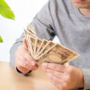 ボーナスを手にする男性のイメージ写真