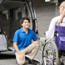 車椅子をサポートする介護士