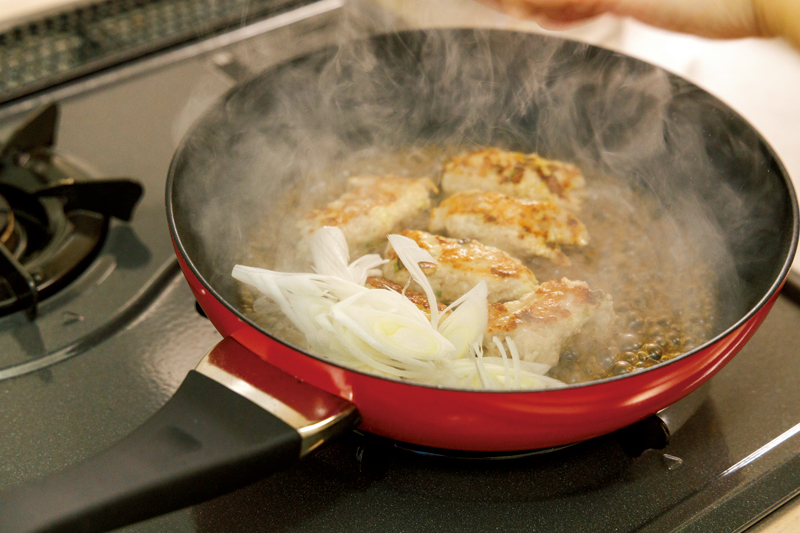 フライパンで焼いた肉ダネ、ネギ、タレを入れて煮詰めている画像