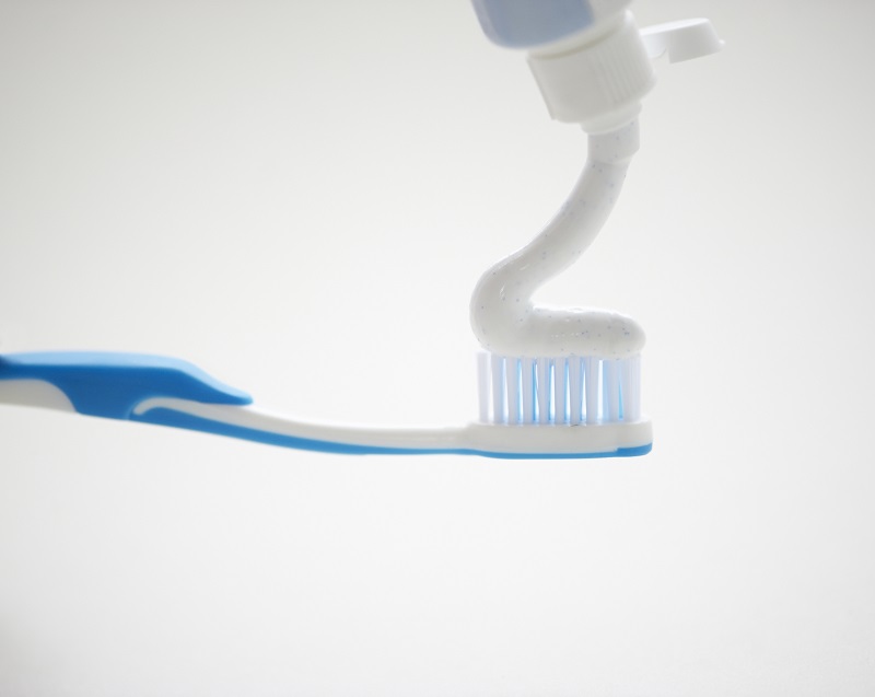 歯ブラシに歯磨きをを絞っている画像
