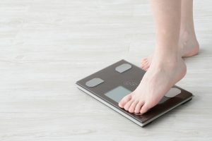 体重計に乗ろうとしている女性