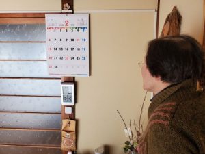 カレンダーで曜日を確認する工藤広伸さんのお母さん