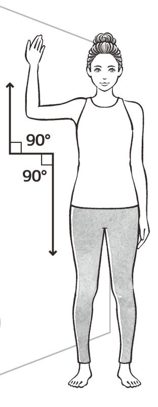 壁に対して横向きになり、少し離れたところに立つ女性のイラスト