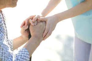 手を取り合う高齢者と若者