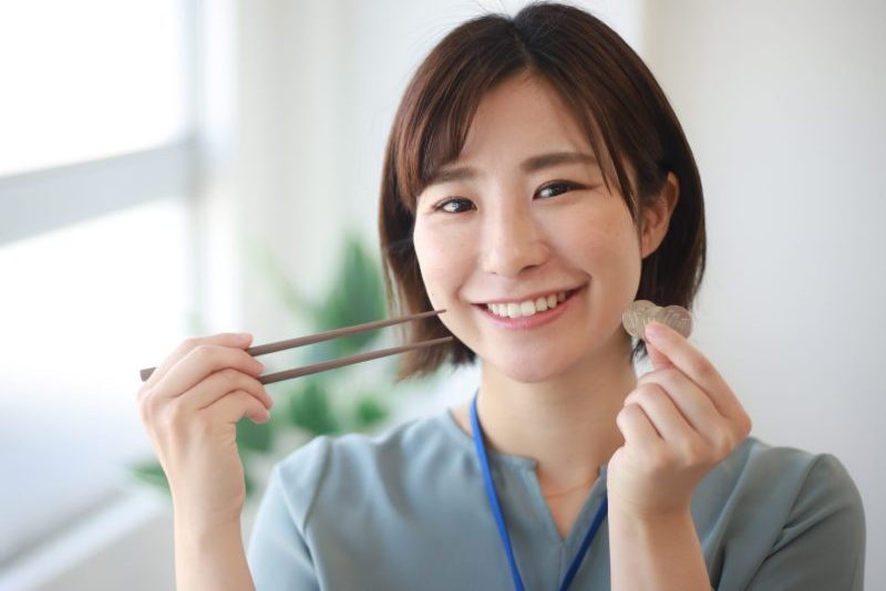 百円玉とお箸を手にする女性