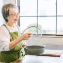 キッチンに立つシニア女性の写真