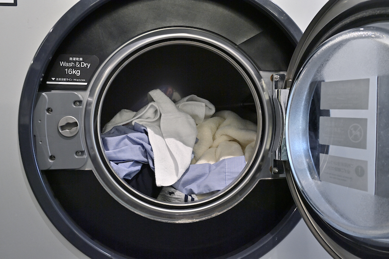 コインランドリーの洗濯機に洗濯物を入れる
