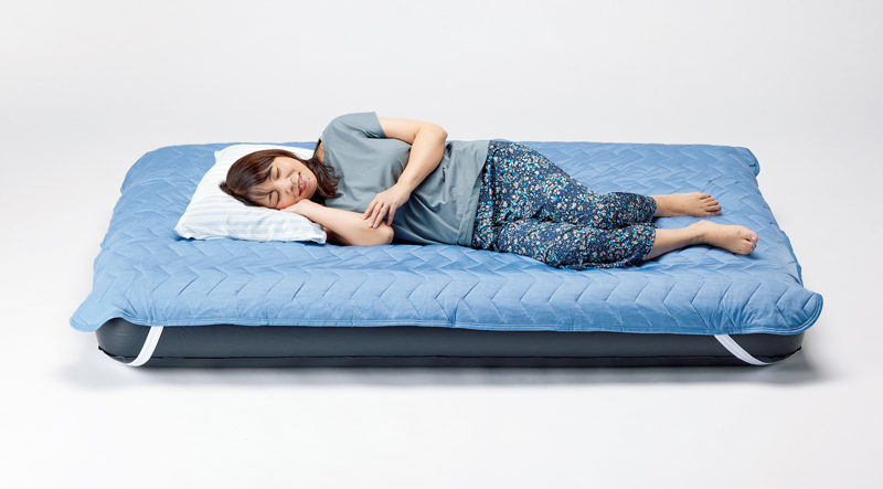 「Nクール」敷きパッドダブル、冷感 枕カバーの寝具に「Nクール」パンツを履いて横たわる女性