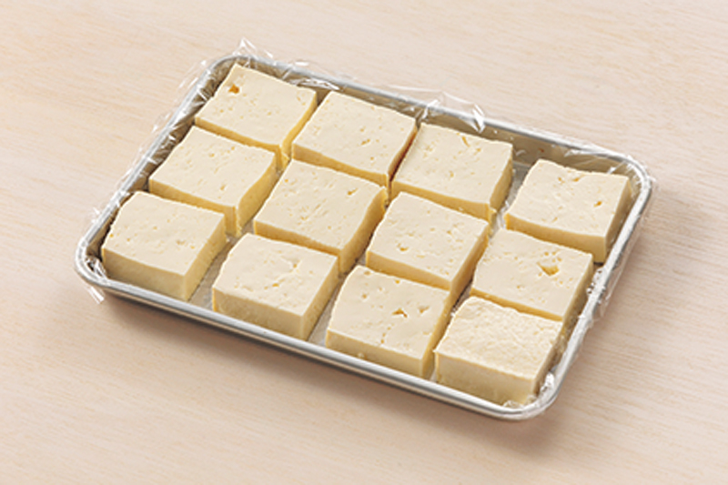 【1】水気を切った木綿豆腐を食べやすい大きさに切りラップを敷いたトレイに並べる